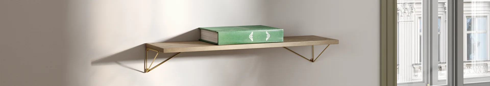 Um livro verde repousa numa prateleira de madeira com suportes dourados, iluminado por luz natural perto de uma janela.