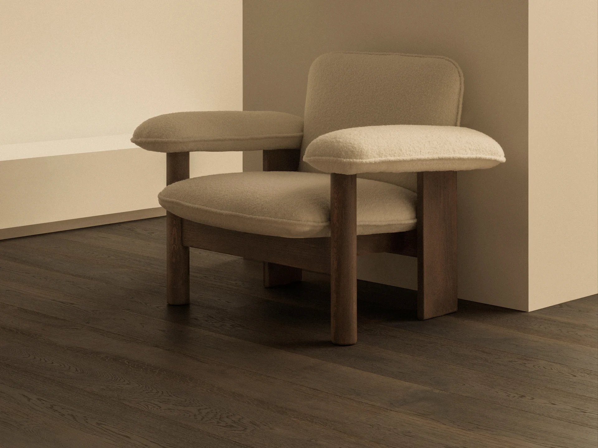 Um quarto minimalista com uma poltrona estofada bege, pisos de madeira escura e um moderno candeeiro de parede em latão com globo branco.